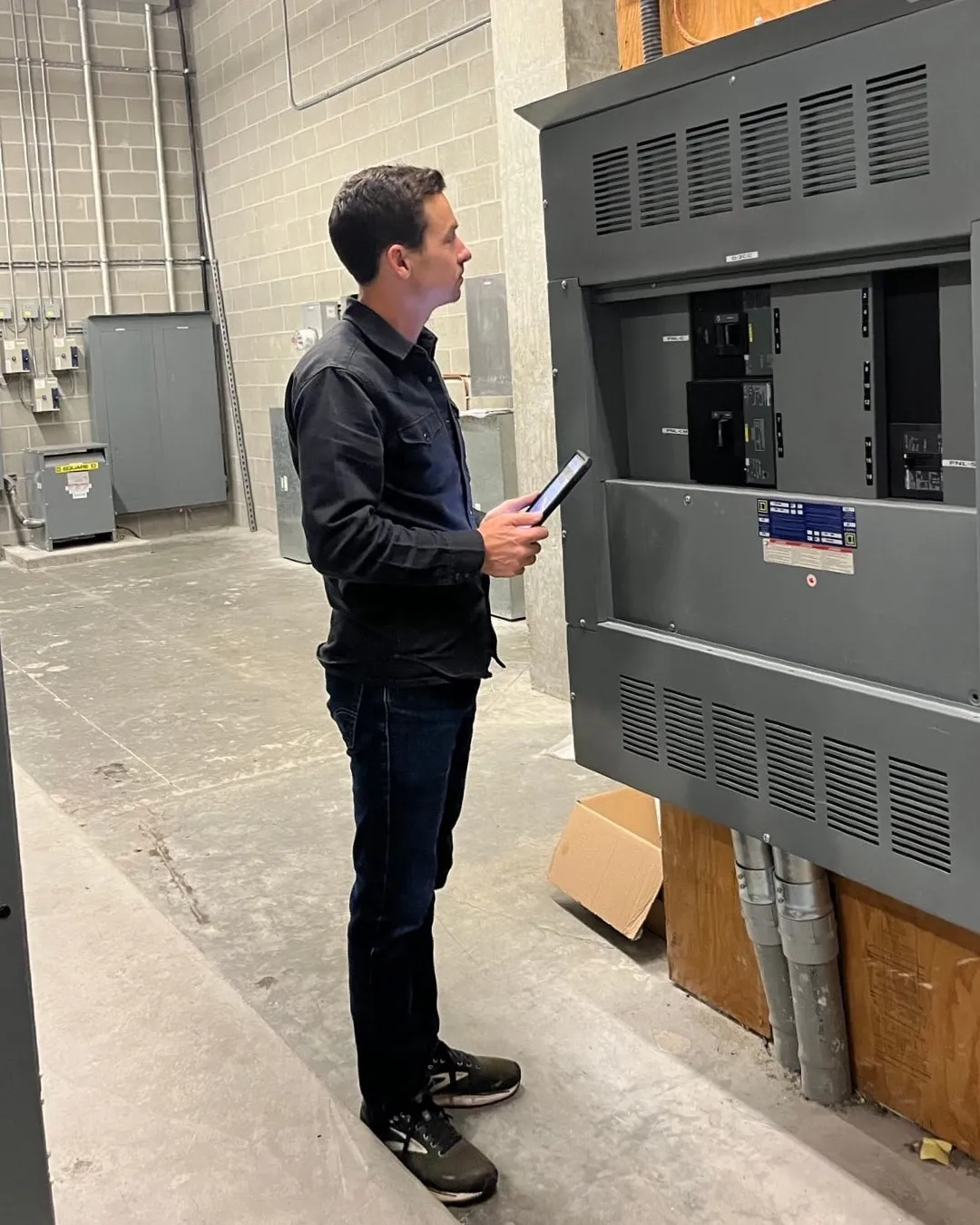 Chris Farrar in a strata building's main electrical room during a property assessment